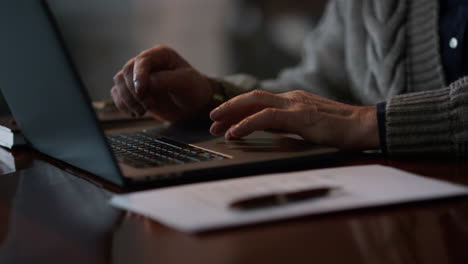Old-man-hands-touching-touchpad-laptop-at-home.-Unknown-gentleman-using-computer