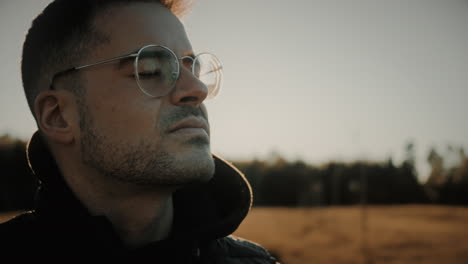 a young caucasian man spends time alone outdoors reflecting on his life decisions, grateful and enjoying the fresh air that he is breathing