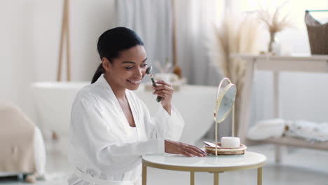 woman applying facial roller in bathroom