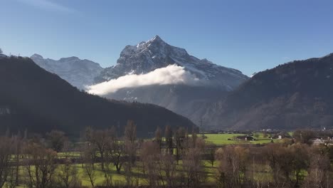 swiss alps mountain range with clouds and valley