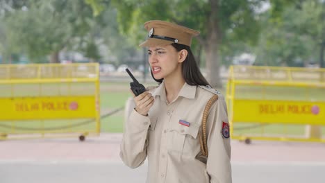 angry indian female police officer shouting on walkie talkie