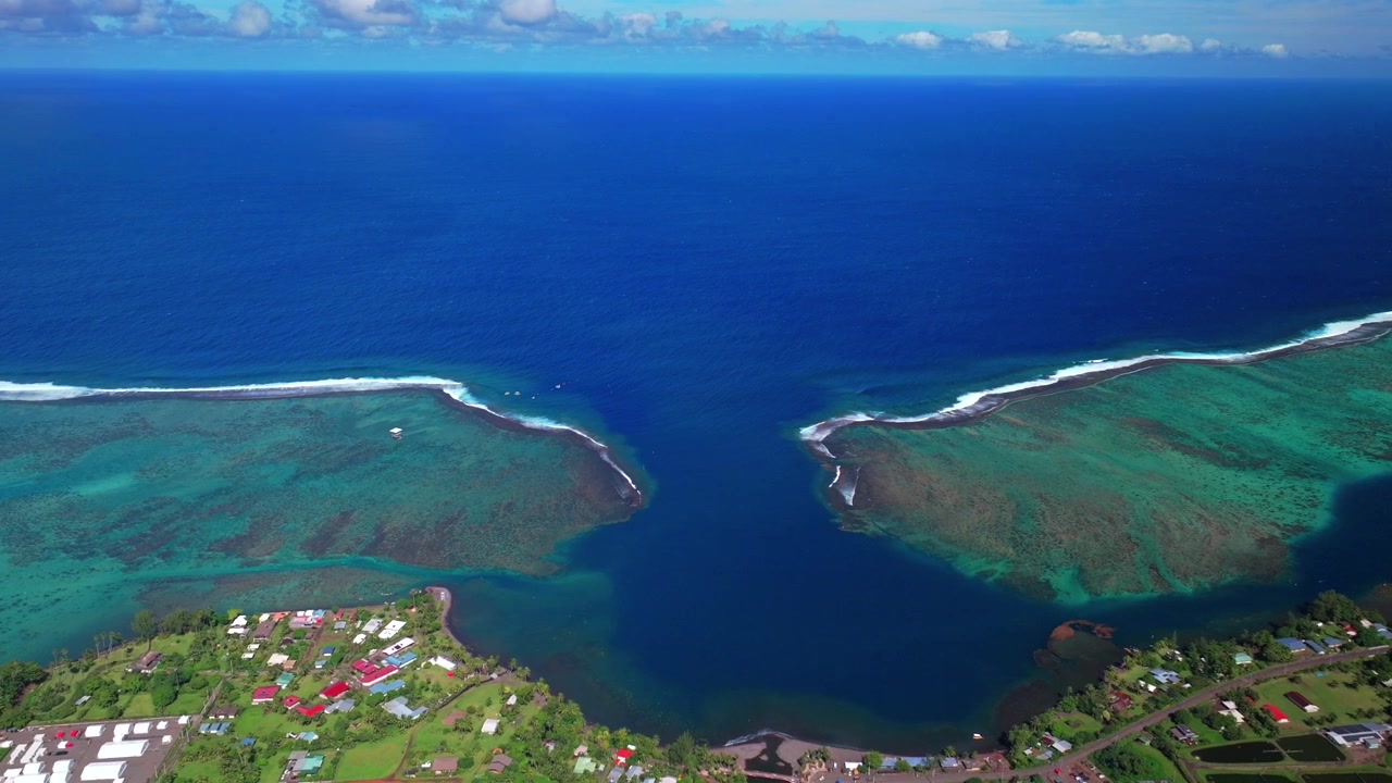 Vista aérea por drone da vila de Teahupo'o, Fim da Estrada, Taiti, Polinésia Francesa, em uma manhã ensolarada de céu azul, mostrando o bairro, a onda de Teahupo'o, a lagoa de surf, o recife de coral Passe Havea e o Rio Vaiau em sentido inverso.