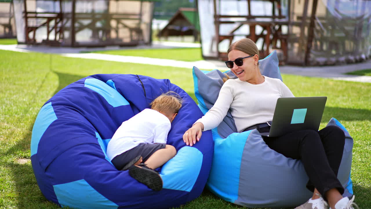 Mother and Son Relaxing Outdoors with Laptop