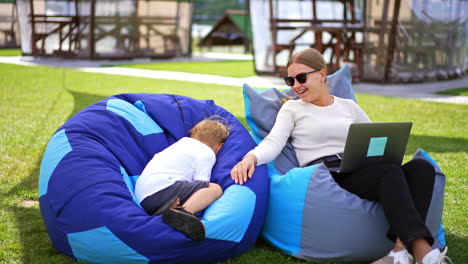 mother and son relaxing outdoors with laptop