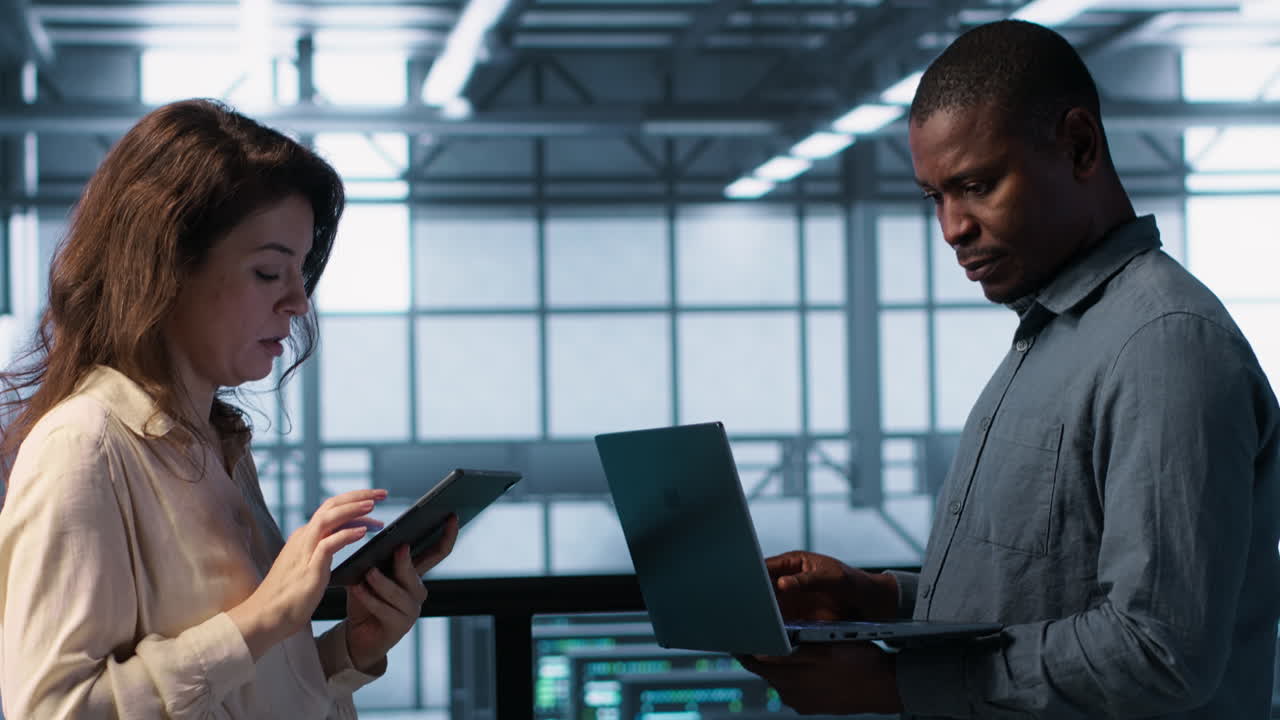 Portrait of happy system administrators in data center using devices