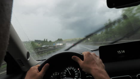conducir un coche bajo la lluvia con los limpiadores de parabrisas encendidos