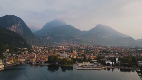 timelapse de hiperlapso aéreo de drones de la ciudad de riva del garda, italia y barco navegando en el lago por puerto