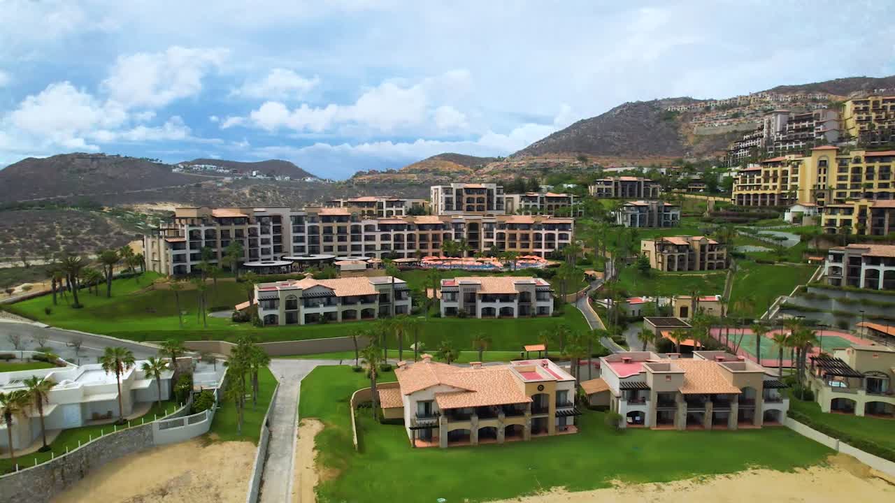 toma aérea de un hotel y una villa frente a la playa en cabo san lucas méxico