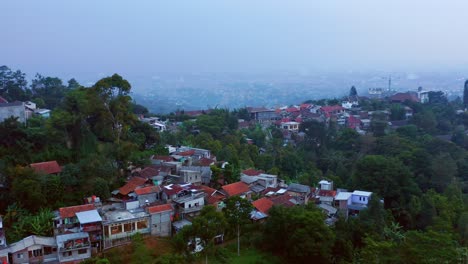 Fly-Over-Tropical-Mountain-Villages-On-A-Foggy-Morning-In-Bandung,-Indonesia