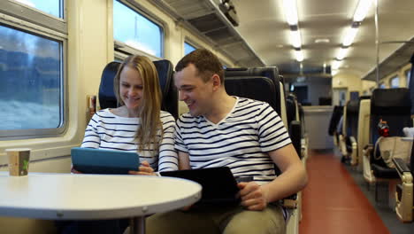 woman with pad and man laptop talking in the train