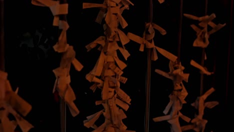 a serene japanese temple glows softly under the night sky, adorned with fluttering wishing papers tied to wooden frames.