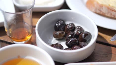 black olives in a white bowl on a wooden table