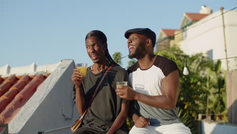 medium shot of cute gays sitting on rooftop and having fun