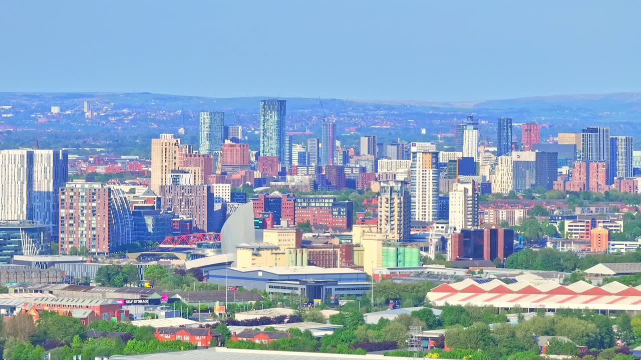 Aerial: Manchester cityscape during the day in Greater Manchester, England, pan drone shot