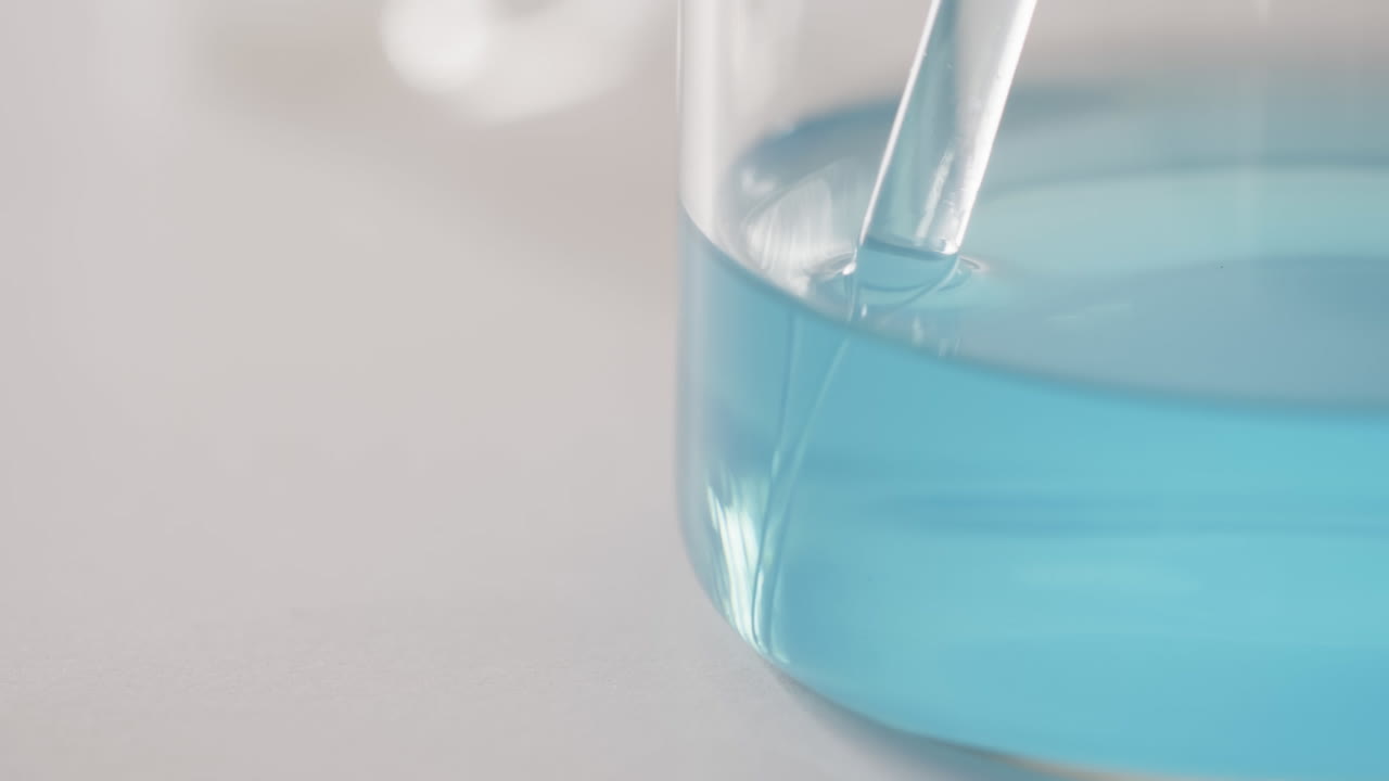 바탕에 복사 공간을 가진 파란 액체와 함께 유리 실험실 접시의 비디오