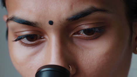 close-up of a woman scientist using a microscope