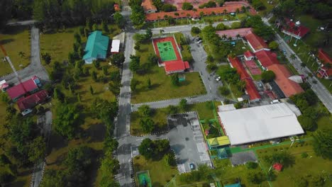 Cinematic-Drone-Footage-of-Palm-Oil-Mill-Effluent-residential-consists-of-buildings,-homes,-main-road-and-infrastructure-surrounded-by-palm-oil-trees-deforestation-located-in-Indonesia-in-full-HD