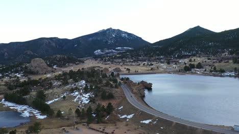 motorcyclist on mountain valley lake road aerial pan shot 4k