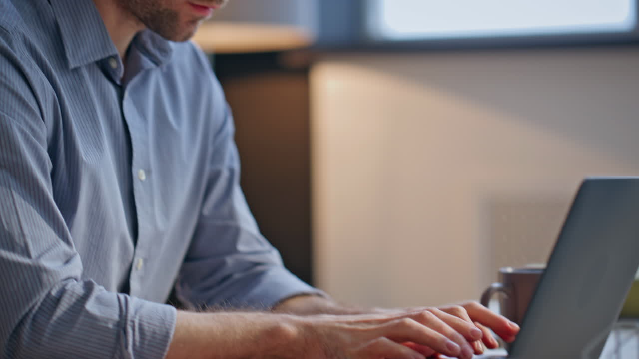 Mani del manager che digitano sulla tastiera del laptop seduto alla scrivania, primo piano. Uomo che lavora al computer.