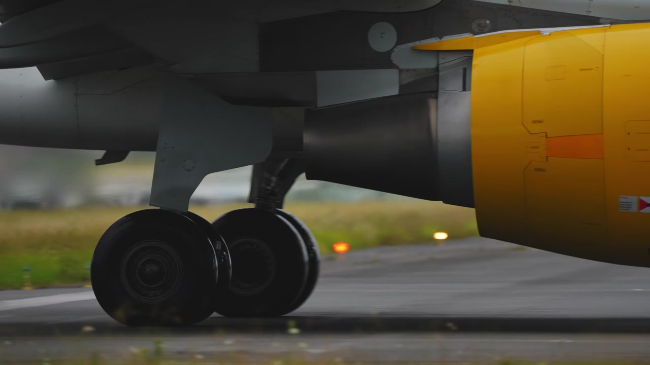 Primo piano del carrello d'atterraggio di un aereo e del motore giallo sulla pista