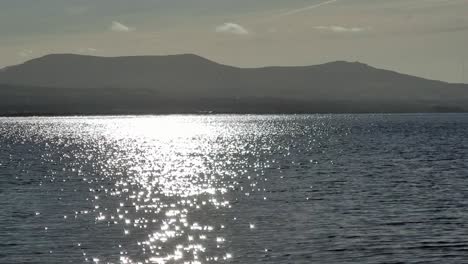 Hazy-Snowdonia-mountain-range-over-shimmering-Irish-Seascape-on-a-peaceful-morning