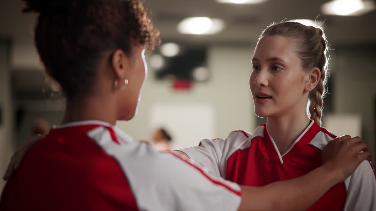 Two women soccer players talking in a locker room