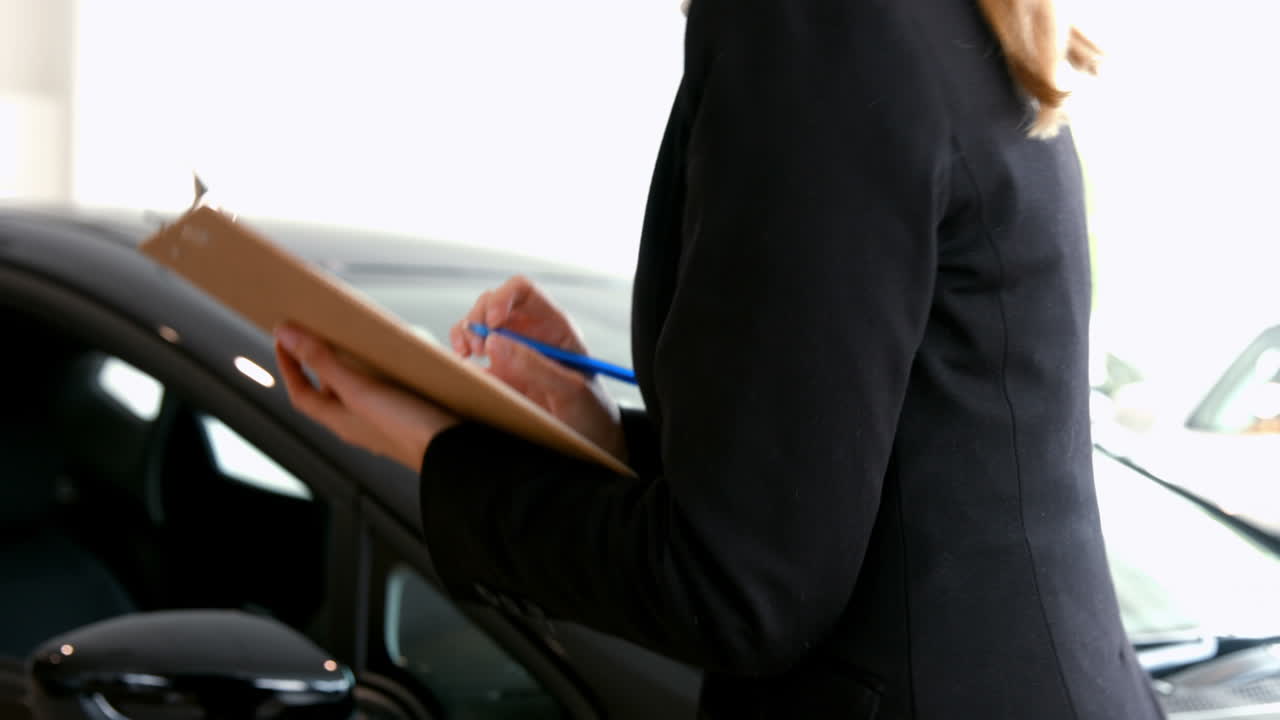 Donna d'affari che esamina un'auto