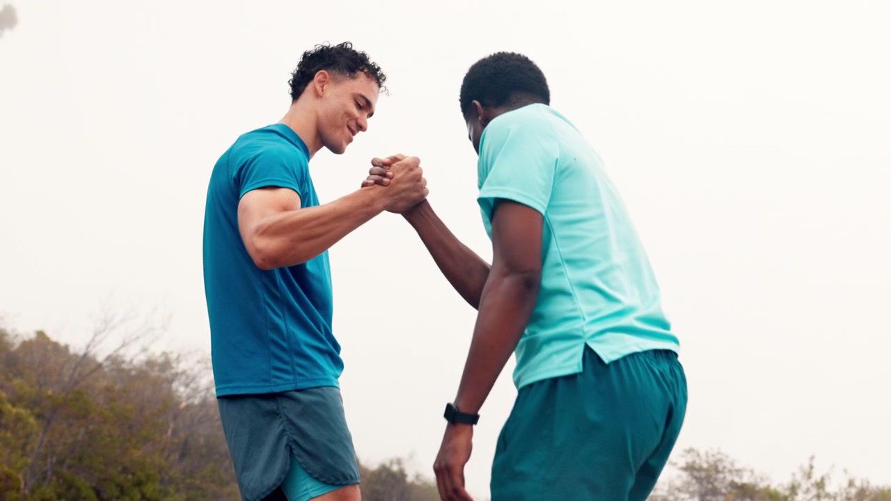 Two Men High-Fiving and Standing Together Outdoors