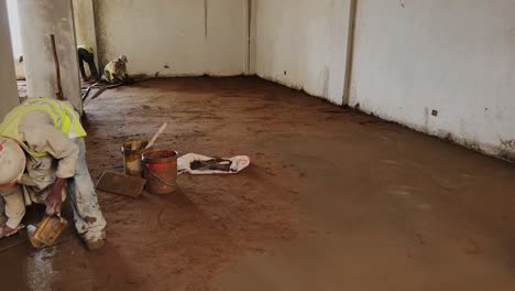 labor leveling concrete on site in building under construction