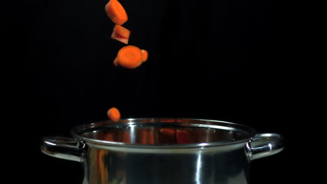 chopped carrots falling into saucepan