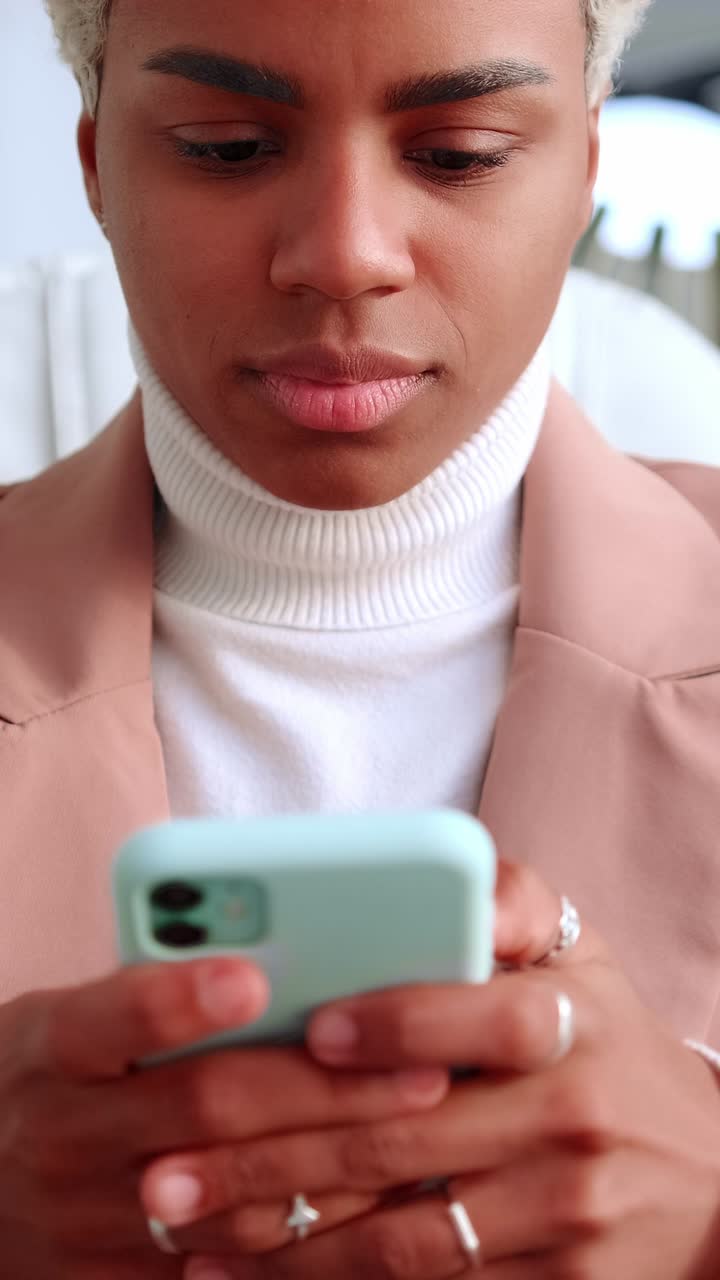 Young professional woman using smartphone in a modern office focused on screen