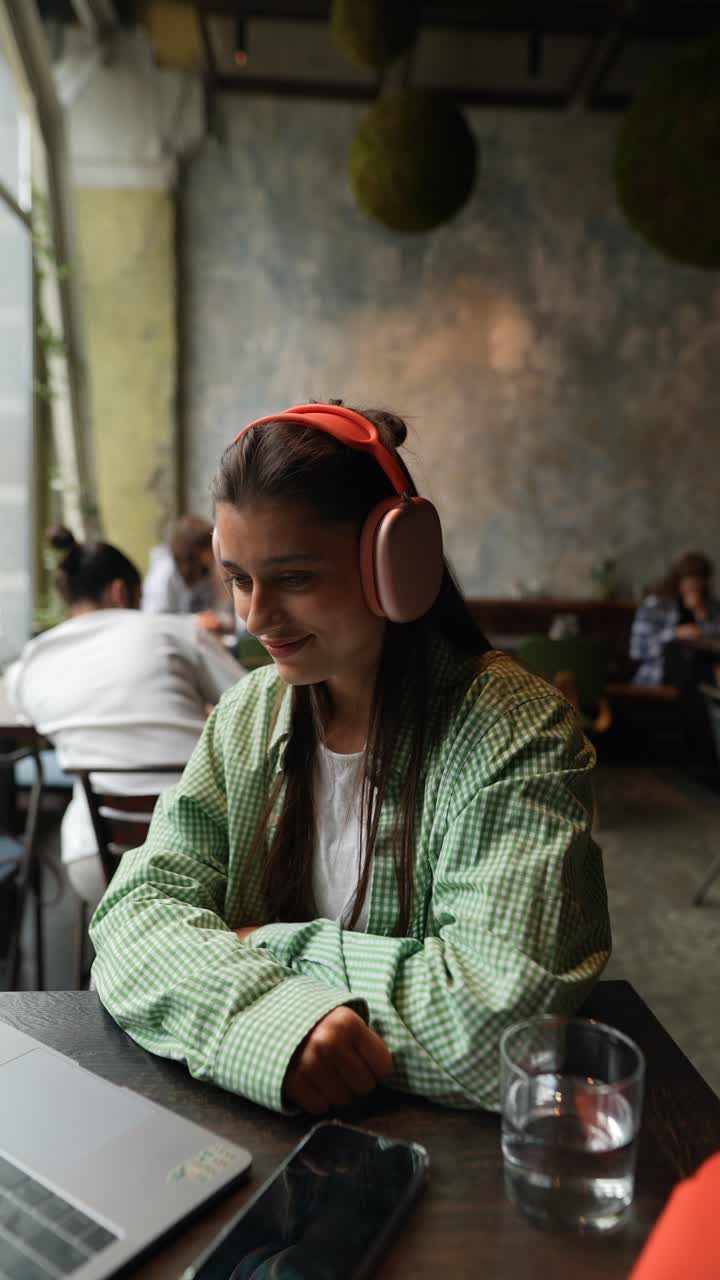 mujer joven trabajando en una computadora portátil en un café