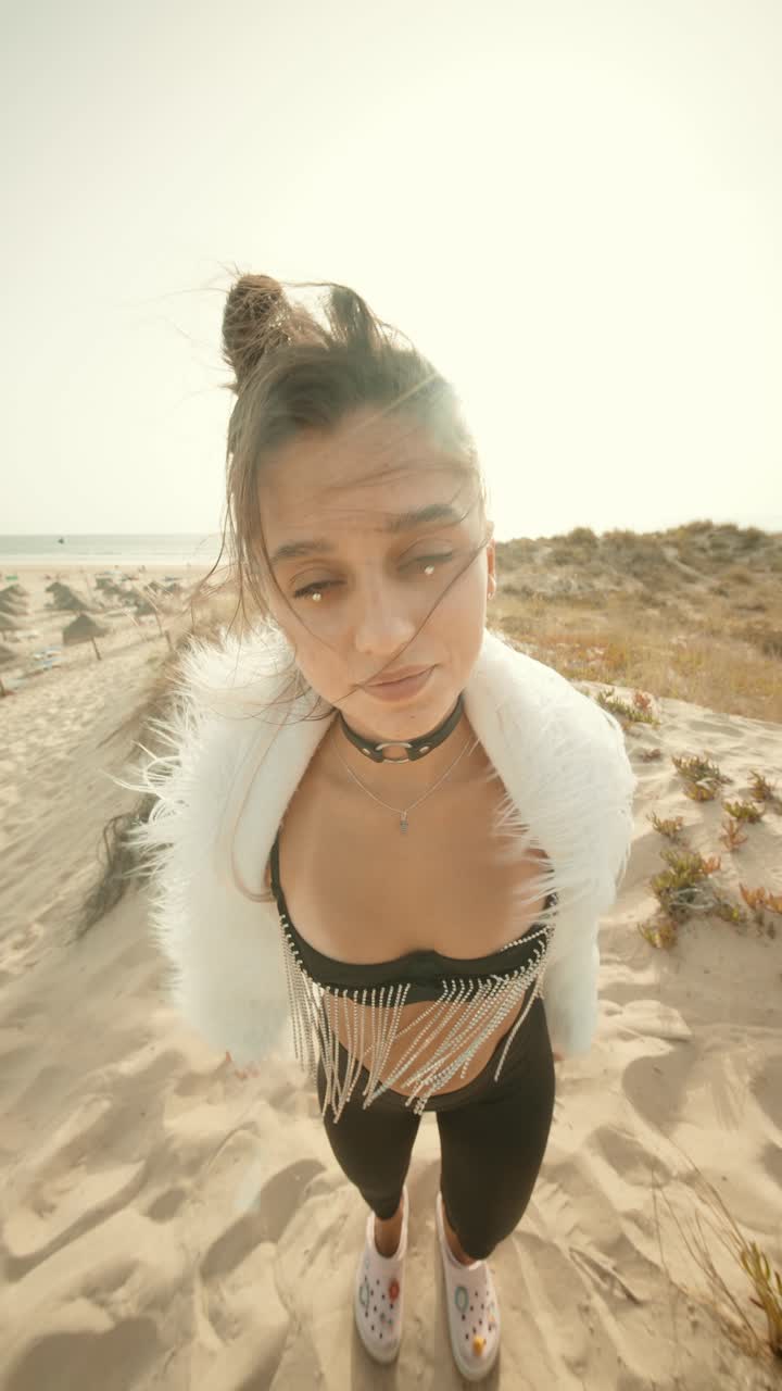 Donna alla moda che posa su una spiaggia