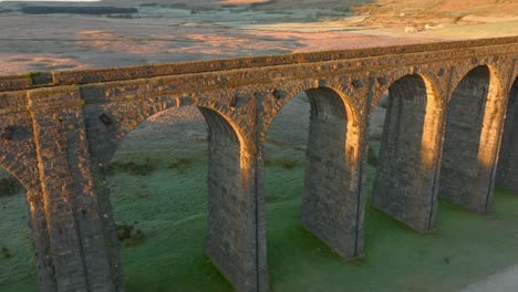 Arches-of-railway-bridge-viaduct-catching-dawn-light-in-winter