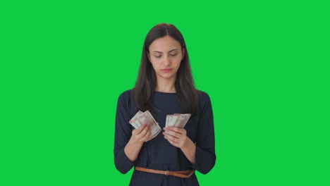 Serious-Indian-girl-counting-money-Green-screen