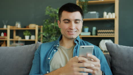 hombre usando teléfono inteligente en el sofá