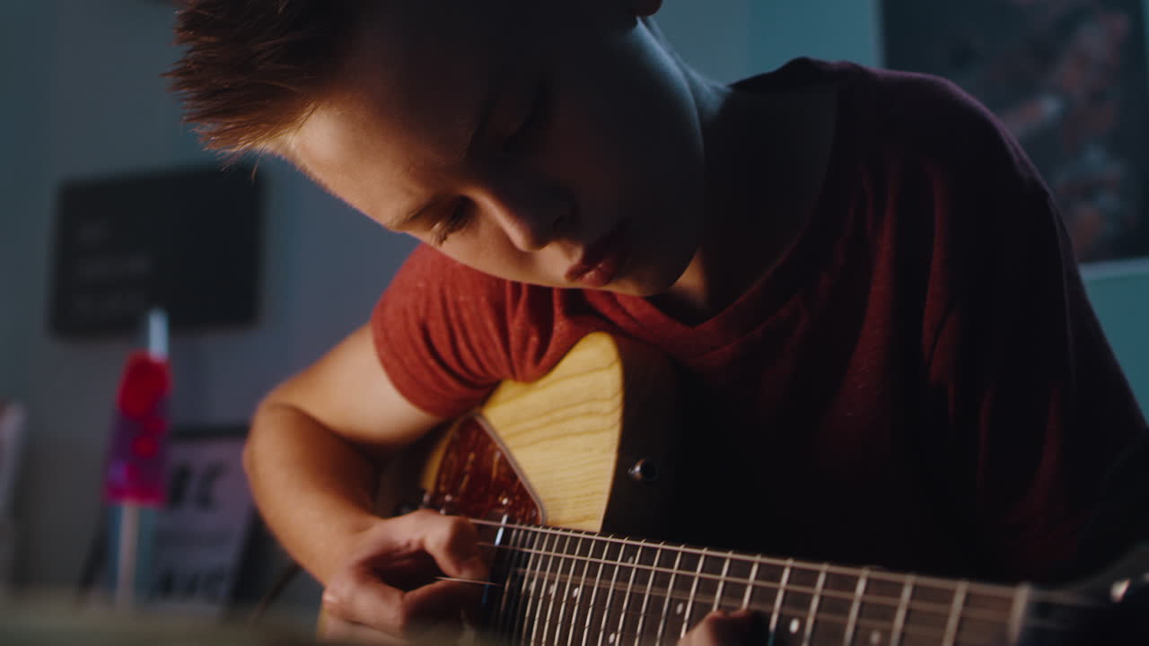 un adolescente tocando la guitarra