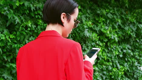 Stylish-Woman-Walking-Along-Urban-Street-Using-Mobile-Phone