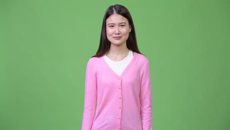 젊은 아름다운 아시아 여성이 엄지손가락을 올리고