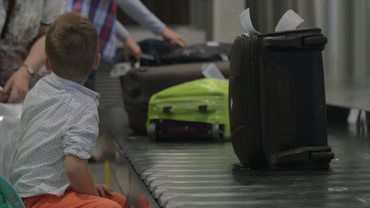 niño pequeño en la zona de recogida de equipaje