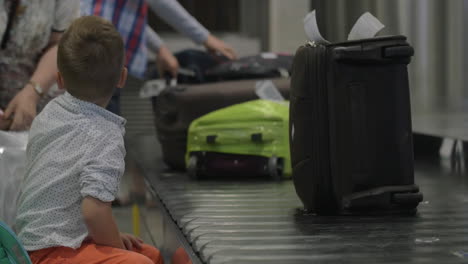 niño pequeño en la zona de recogida de equipaje