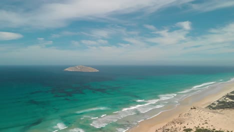 Aerial-shot-of-a-lone-island-out-to-sea-off-the-coast-of-Victoria-Australia