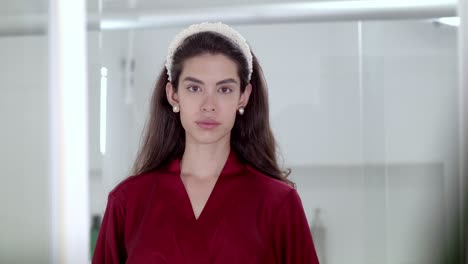 la modelo sonríe con gracia, sus ojos se iluminan y ella agita con encanto radiante