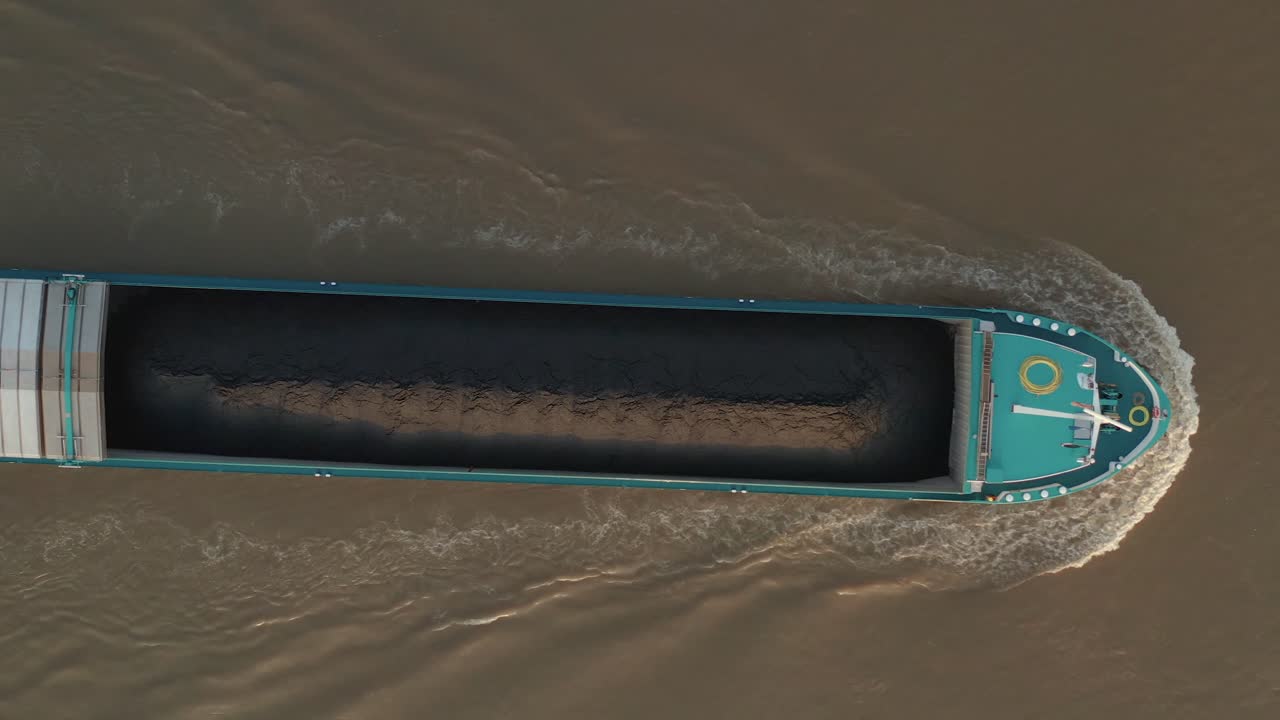 Top shot of a top of a ship boat load and transport coal with a radar device on the brown river rhine 25p