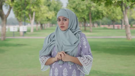 sacred and afraid muslim woman in park