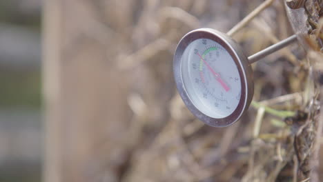 vertical, slow motion - steam rises around the compost thermometer