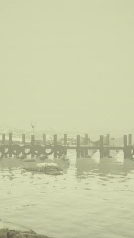 snowy dock by a quiet lake in a foggy winter landscape