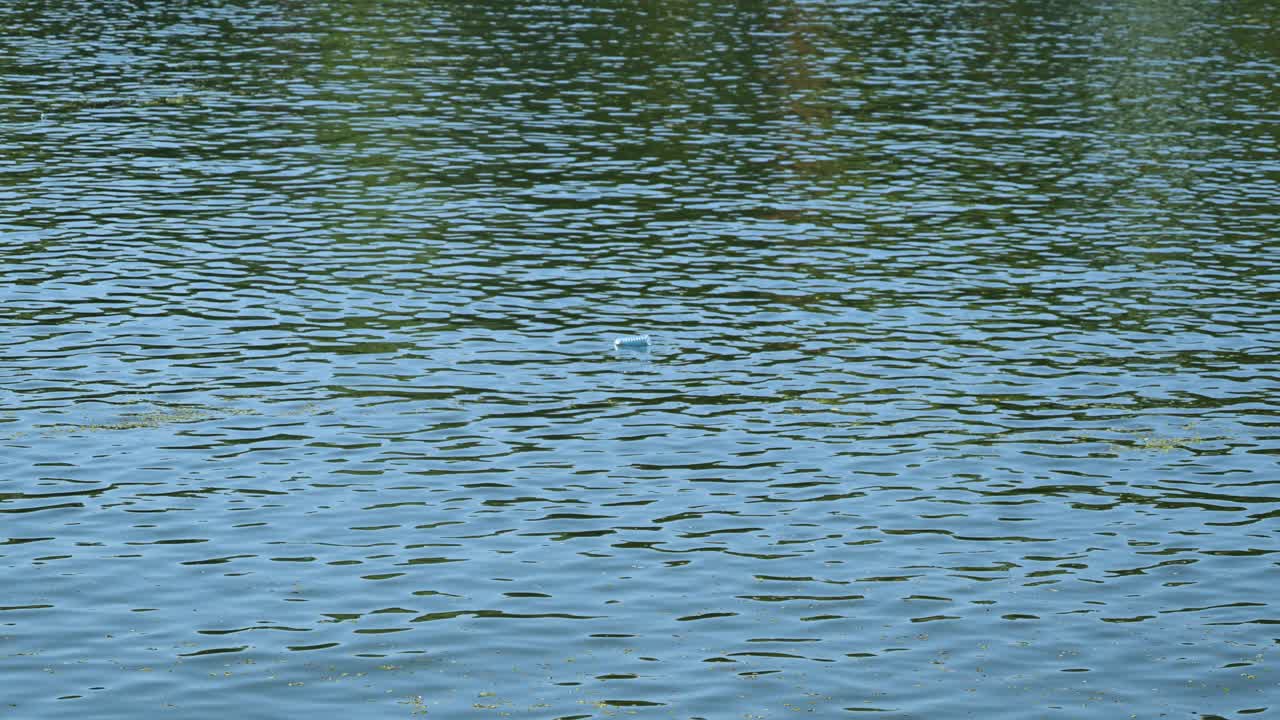 Plastic bottle floating on river water surface