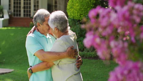 video of happy biracial senior couple embracing in garden