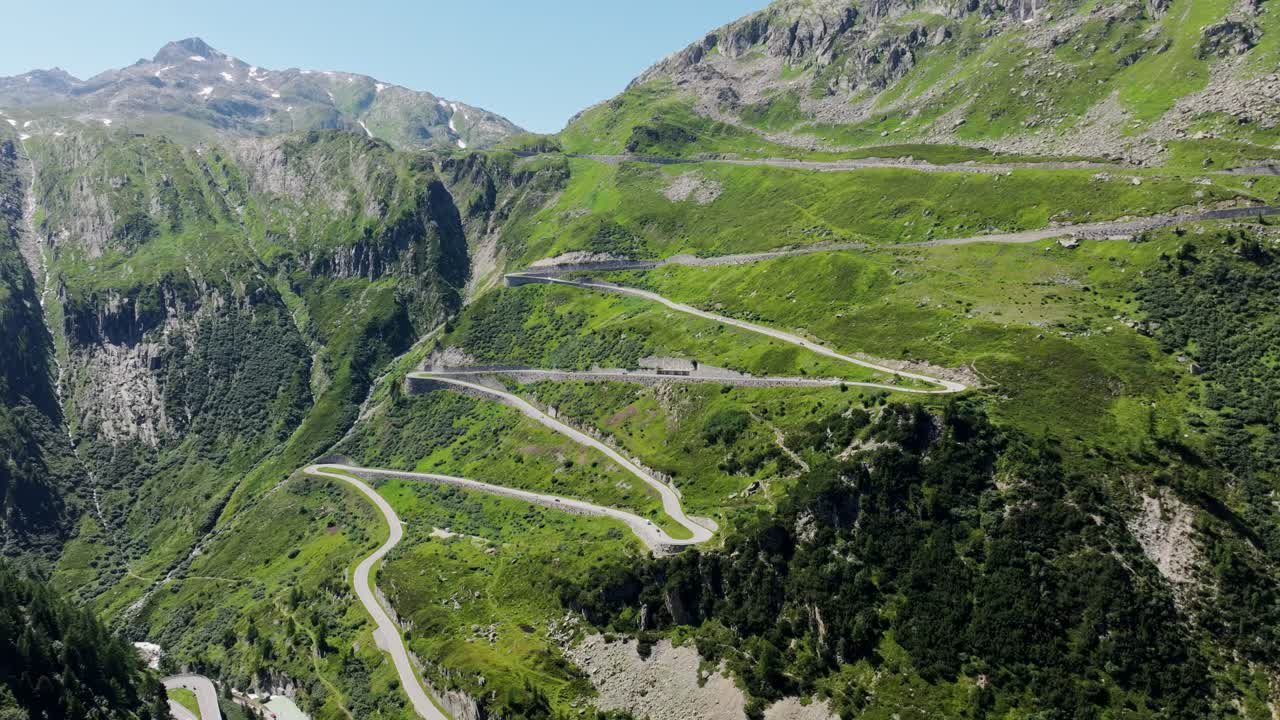 Scenic winding mountain pass, sharp turns, lush alpine landscape, Switzerland
